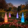 A garden at dusk with four illuminated teardrop-shaped LED lamps in various colors, surrounded by autumn foliage. Produktbild-Vorschau