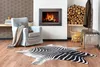 A living room scene with a fireplace, armchair, and a zebra-print rug. Podgląd zdjęcia produktu