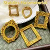 Several ornate, vintage-style miniature picture frames are arranged on a textured surface. Produktbild-Vorschau