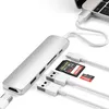A silver USB-C hub is connected to a laptop, with various ports and slots visible. Several memory cards and USB cables are also shown. Voir les images du produit