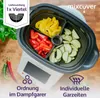 A multi-compartment insert for a steam cooker, filled with chopped vegetables, placed on top of the steam cooker. Produktbild-Vorschau