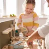 Two children playing with a wooden workbench and tools. Náhled obrázku produktu