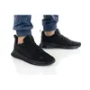 A pair of black Puma sneakers worn by a person. Produktbild-Vorschau