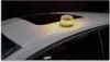 A yellow and white emergency light is placed on the roof of a white car. Produktbild-Vorschau