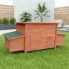 A wooden chicken coop with a green roof sits on a grassy lawn. Produktbild-Vorschau