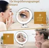 A split image showing two women using a lighted magnifying makeup mirror. The top section shows a woman applying makeup, with a close-up of her eye in the mirror. The bottom section shows another woman using the mirror to apply makeup to her nose. Produktbild-Vorschau