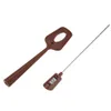 A brown spatula and a silver digital thermometer are shown against a white background. Podgląd zdjęcia produktu