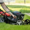 A person is using a lawnmower on a grassy lawn. Produktbild-Vorschau