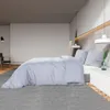 A bedroom scene with a bed, nightstand, and chair. Náhľad obrázku produktu