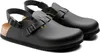 A pair of black Birkenstock clogs with straps and buckles, shown from a slightly elevated side angle against a white background. Produktbild-Vorschau