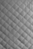 A close-up, full-frame shot of quilted gray material. Náhled obrázku produktu