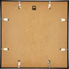 The back of a black picture frame with a brown backing board and silver clips. Produktbild-Vorschau