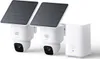 Two white security cameras with solar panels attached, and a white base station. Anteprima dell’immagine prodotto