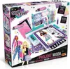 The image shows the packaging of a fashion designer studio toy set, featuring illustrations of dolls and design elements. Podgląd zdjęcia produktu