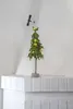 A small, lit Christmas tree sits on a white brick shelf. Produktbild-Vorschau