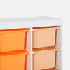 A close-up view of a white shelving unit with six storage bins, three orange and three peach, stacked in two columns. Produktbild-Vorschau