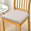 A close-up shot of a beige seat cushion on a wooden chair, with a small white table and a mug visible on the left. Anteprima dell’immagine prodotto
