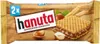 A package of Hanuta Haselnuss Schnitte wafers with chocolate filling, surrounded by hazelnuts and wheat stalks. Anteprima dell’immagine prodotto