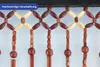 A close-up view of a beaded curtain made of wooden beads. Produktbild-Vorschau