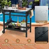A grill cart is set up on a wooden deck next to a swimming pool, with food and drinks on it. Produktbild-Vorschau