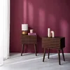 Two wooden nightstands with a slatted design are placed against a deep pink wall. One nightstand has a lamp and books, while the other has two decorative vases. Produktbild-Vorschau