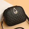 A black quilted leather crossbody bag with gold hardware is displayed against a light beige and white background. Náhled obrázku produktu
