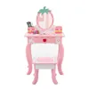 A pink children's vanity table and stool set with a strawberry-shaped mirror and various toy makeup accessories. Podgląd zdjęcia produktu