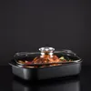 A roasted chicken and vegetables in a roasting pan with a glass lid, set against a dark background. Produktbild-Vorschau