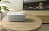 A Sony SRS-LSR200 portable speaker sits on a wooden coffee table in front of a television. Voir les images du produit