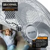 A woman relaxing on a couch with a laptop, with a large fan in the background. Náhled obrázku produktu