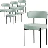 A group of six green chairs are arranged in the background, with one chair in the foreground.