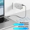 A white 65W GaN charger is plugged into a white wall socket, with a braided USB-C cable connecting it to a silver laptop. The image also displays text indicating charging times for a MacBook Pro 13 and a Mi Gaming Laptop. Produktbild-Vorschau