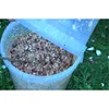 A bucket filled with chopped apples and a lid being held open, sitting on grass. Produktbild-Vorschau