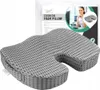A grey orthopedic seat cushion is shown in front of its packaging, which features a woman sitting at a desk. Náhled obrázku produktu