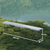 A white folding bench is placed on a grassy area next to a body of water. Produktbild-Vorschau