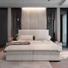 A modern bedroom with a large boxspring bed as the focal point. Produktbild-Vorschau