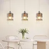 Three pendant lights hanging above a dining table with a vase of flowers. Anteprima dell’immagine prodotto