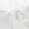 A close-up view of a white zipper on a white fabric product, with white stuffing visible through the open zipper. Produktbild-Vorschau