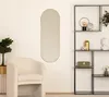 A modern living room with a mirror, chair, and shelving unit. Podgląd zdjęcia produktu