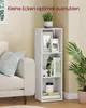A white three-tier shelf unit is placed next to a sofa in a room. The shelf unit contains books, picture frames, and a plant. Produktbild-Vorschau