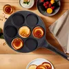 A pancake pan with pancakes cooking, surrounded by breakfast items like yogurt, berries, and a drink. Náhled obrázku produktu