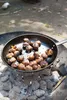 Chestnuts are being roasted in a pan over coals. Produktbild-Vorschau