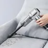 A hand is holding a portable vacuum cleaner and cleaning a sofa. Produktbild-Vorschau