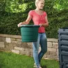 A woman is holding a green bucket next to a compost bin in a garden. Voir les images du produit