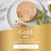 A close-up of a round, tan-colored cat food mousse on a white plate, with some parsley sprigs and a golden overlay with text. Podgląd zdjęcia produktu
