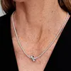 A close-up shot of a person wearing a silver necklace with a bow pendant. Podgląd zdjęcia produktu