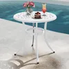A white round table with a cake, flowers, and a drink on it, placed next to a swimming pool. Podgląd zdjęcia produktu