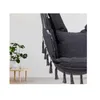 A dark gray hanging chair with tassels is shown in a room with a plant and a small table. Produktbild-Vorschau