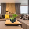 A living room scene with a sectional sofa, coffee table, and decorative items. Produktbild-Vorschau