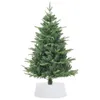 A green artificial Christmas tree with a white base, isolated on a white background. Podgląd zdjęcia produktu